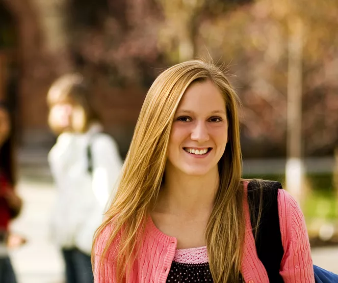 Student on campus holding books